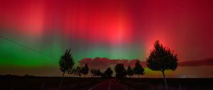 Polarlichter leuchten am Nachthimmel über einer Straße im östlichen Brandenburg.