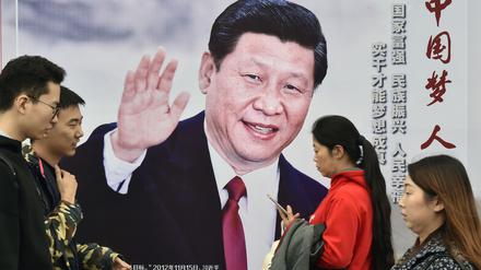 Passanten gehen am 17.10.2017 in Peking (China) an einem Plakat vorbei, das den chinesischen Präsidenten Xi Jinping zeigt.