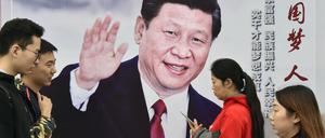 Passanten gehen am 17.10.2017 in Peking (China) an einem Plakat vorbei, das den chinesischen Präsidenten Xi Jinping zeigt.