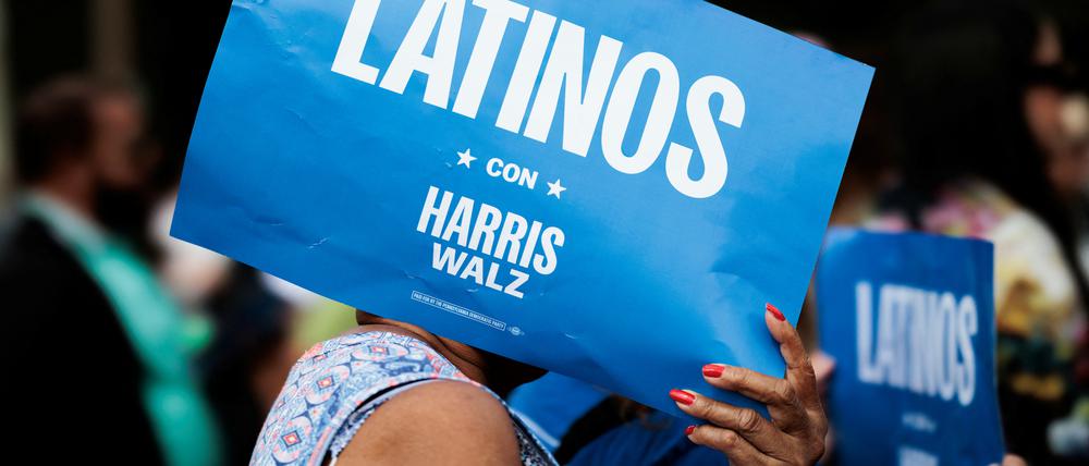 Eine Zuhörerin hält ein „Latinos mit Harris-Walz“-Schild bei einem Event in Allentown, Pennsylvania, hoch.