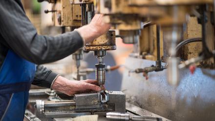 Ein Mitarbeiter bedient in der Produktionshalle der Firma Impulsa AG eine Maschine zur Verarbeitung von Metall. 