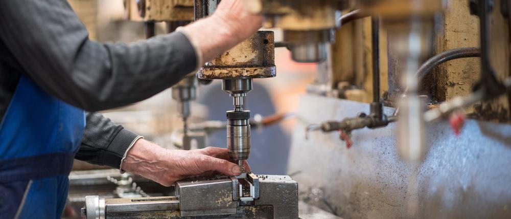 Ein Mitarbeiter bedient in der Produktionshalle der Firma Impulsa AG eine Maschine zur Verarbeitung von Metall.