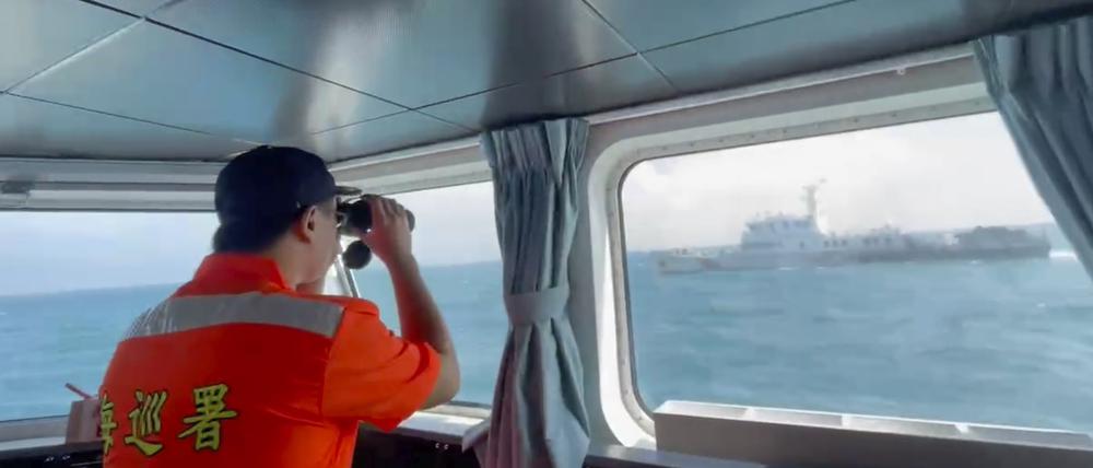 Ein Mitglied der taiwanischen Küstenwache beobachtet ein Boot der chinesischen Küstenwache, das an der Küste der Matsu-Inseln in Taiwan vorbeifährt.