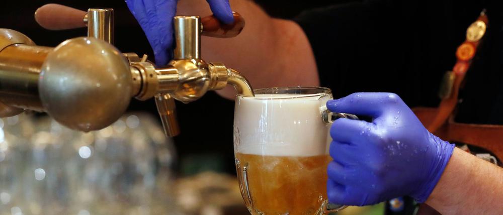 Ein Barkeeper zapft ein Bier auf einer Restaurant-Terrasse. (Symbolbild)