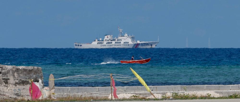 Ein Fischerboot fährt vor der Insel Thitu an einem Schiff der chinesischen Küstenwache vorbei (Symbolbild).