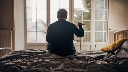 Allein im Heim: Ein Mann sitzt auf seinem Bett.