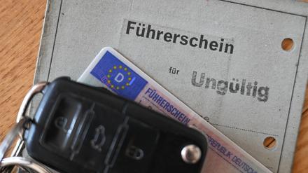 Ein Autoschlüssel liegt auf einem ungültigen alten Papierführerschein. 