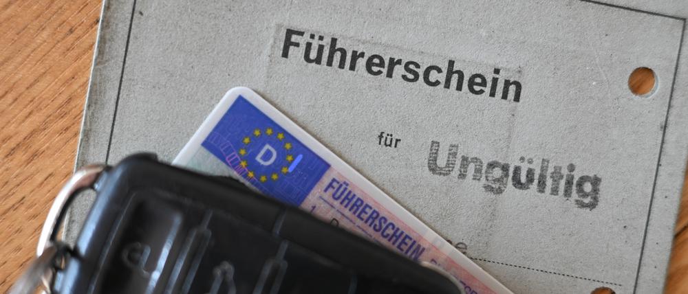 Ein Autoschlüssel liegt auf einem ungültigen alten Papierführerschein. 