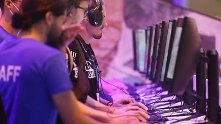 Messebesucher testen ein Computerspiel bei der Gamescom 2022. 