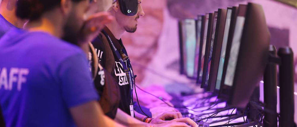 Messebesucher testen ein Computerspiel bei der Gamescom 2022.