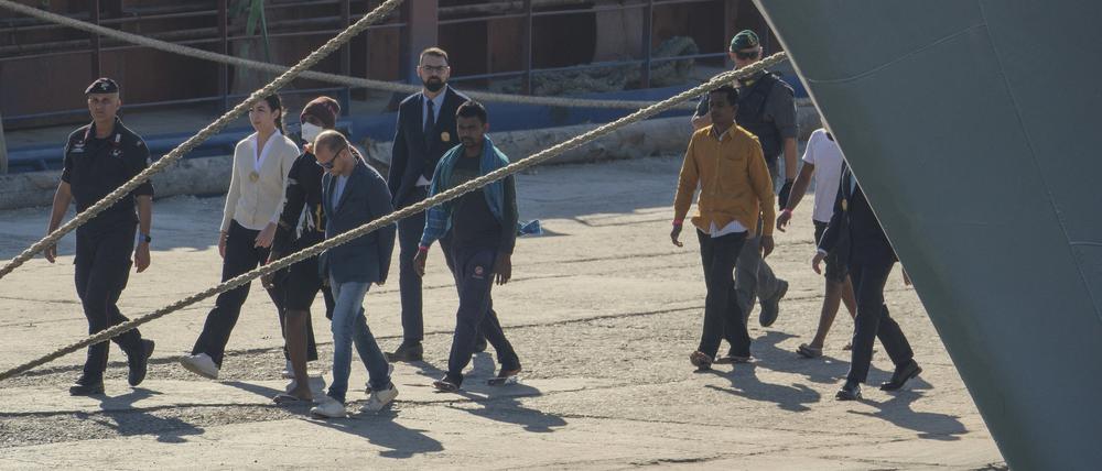 Migranten und Sicherheitspersonal kommen im Hafen von Shengjin im Nordwesten Albaniens an, nachdem das italienische Marineschiff Libra die erste Gruppe von 16 Migranten, die in internationalen Gewässern aufgegriffen wurden, an Land gebracht hat.