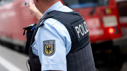 Bayern, München: Ein Bundespolizist steht am Hauptbahnhof an einem Bahnsteig vor einem Zug der Deutschen Bahn.