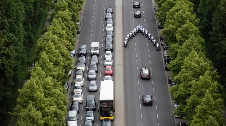 Die Fahrzeugkolonne mit der damaligen Königin Elizabeth II. und ihrem Gatten Prinz Philip (r, zweite Fahrzeug von unten) fuhr am 24.06.2015 in Berlin auf der Straße des 17. Juni durch den Tiergarten. Die Straße wurde dafür gesperrt, Berlinerinnen und Berliner standen im Stau.