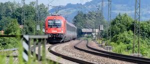 Ein Zug der Österreichischen Bundesbahnen (ÖBB) fährt über die Gleise der Bahntrasse durch das Inntal zwischen Rosenheim und Kufstein.