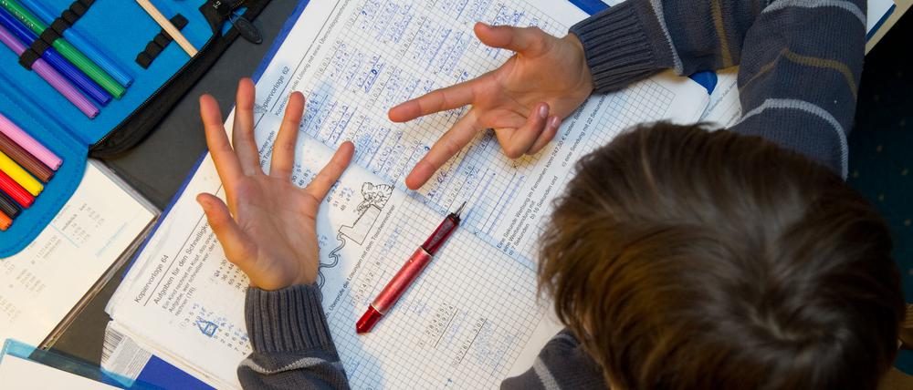 Ein Schüler rechnet bei den Matheaufgaben mit den Fingern.