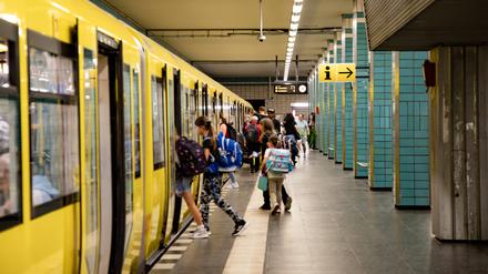 Kinder steigen in einen Zug der Linie U5 am Bahnhof Tierpark.