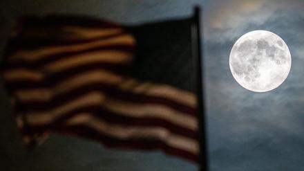 Ein besonders groß erscheinender Vollmond, auch Supermond genannt, ist bei leichter Bewölkung hinter der Flagge auf der US-Botschaft zu sehen. 