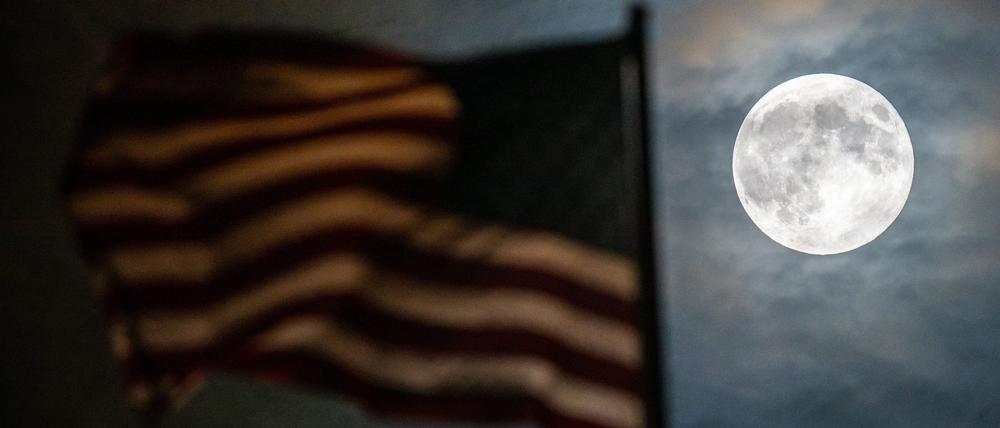 Ein besonders groß erscheinender Vollmond, auch Supermond genannt, ist bei leichter Bewölkung hinter der Flagge auf der US-Botschaft zu sehen. 