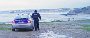 Ein französischer Polizist blickt über die Küste bei Wimereux, nördlich von Boulogne in Nordfrankreich, auf einen Strandabschnitt, der vermutlich von Migranten genutzt wird, um den Ärmelkanal zu überqueren. Bei der versuchten Überquerung des Ärmelkanals von Frankreich nach Großbritannien durch Dutzende Migranten ist ein Säugling ums Leben gekommen.
