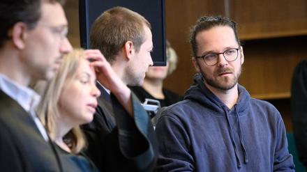 Arne Semsrott (r), Chefredakteur des Internetportals «FragdenStaat» steht zu Beginn eines Prozesses gegen ihn mit seinen Rechtsanwälten Benjamin Lück (l-r), Hannah Vos und Lukas Theune im Verhandlungssaal im Berliner Landgericht. Die Anklage wirft dem Journalisten verbotene Veröffentlichung von Gerichtsbeschlüssen vor. Der Journalist soll im August 2023 unter anderem Durchsuchungsbeschlüsse aus einem laufenden Ermittlungsverfahren gegen die Klimagruppe Letzte Generation, die zum Teil geschwärzt waren, in einem Artikel veröffentlicht haben. 
