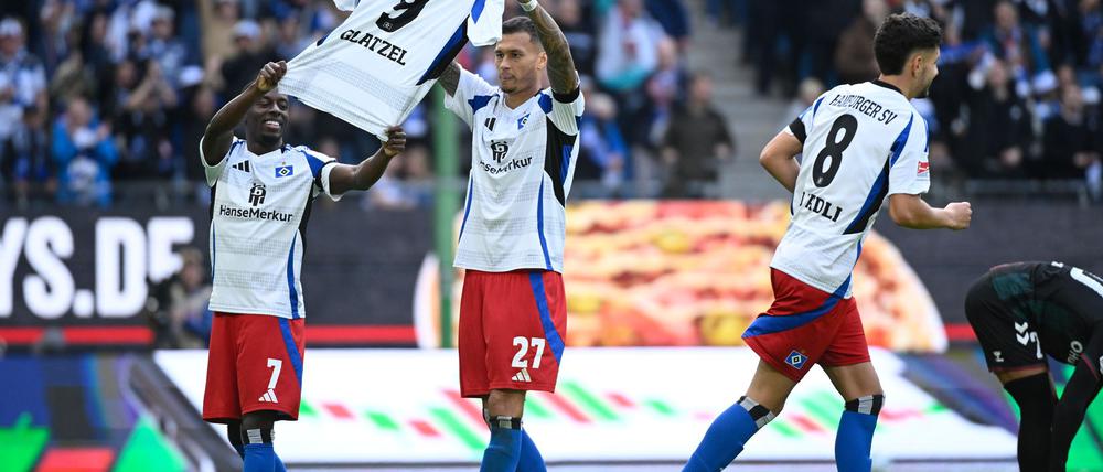 Gruß an Glatzel: Die HSV-Spieler Davie Selke (M) und Jean-Luc Dompe jubeln mit einem Trikot ihres verletzten Torjägers.