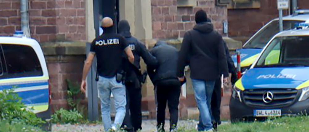 Polizisten bringen den in Bernau bei Berlin festgenommenen mutmaßlichen IS-Unterstützer zur Haftvorführung beim Bundesgerichtshof.