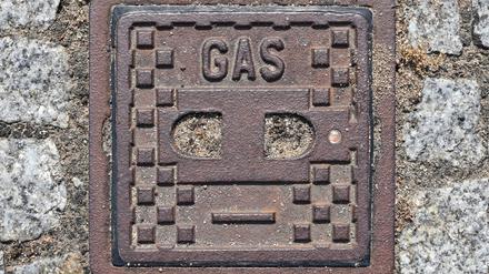 Auf einer Abdeckung einer Metallplatte im Fußweg steht das Wort „Gas“. Unter dem Deckel befindet sich eine Absperrvorrichtung für einer Gasleitung. 