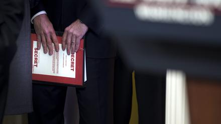 Ein Mitarbeiter hält einen Ordner mit der Aufschrift Secret. (Symbolbild)