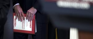 Ein Mitarbeiter hält einen Ordner mit der Aufschrift Secret. (Symbolbild)