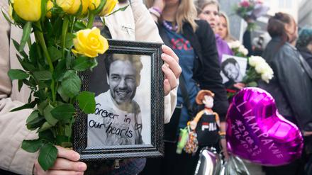 Fans trauern in Köln um Liam Payne und zeigen ein Foto des Sängers, der am Mittwoch vom Balkon seines im dritten Stock gelegenen Hotelzimmers in der argentinischen Hauptstadt Buenos Aires stürzte und starb.