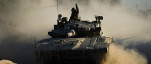Ein israelischer Soldat winkt aus einem fahrenden Panzer nahe der Gaza-Grenze im Süden Israels. (Symbolbild)