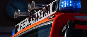 Ein Einsatzfahrzeug der Feuerwehr mit eingeschaltetem Blaulicht.