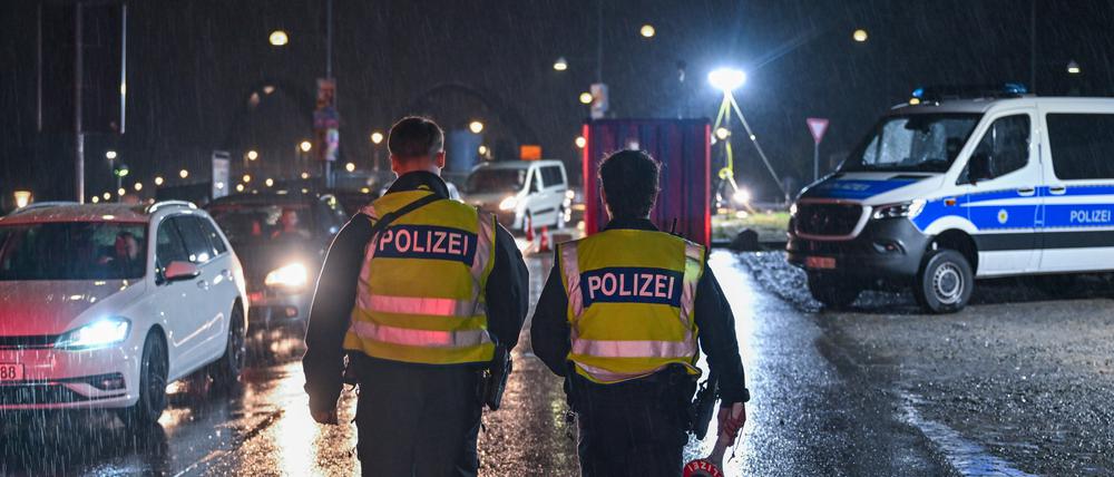 Am frühen Morgen gehen im strömenden Regen zwei Beamte der Bundespolizei am deutsch-polnischen Grenzübergang Stadtbrücke in Frankfurt (Oder) entlang und überwachen den Einreiseverkehr nach Deutschland.