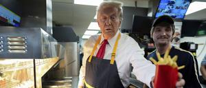 Donald Trump (l), Präsidentschaftskandidat der Republikaner und ehemaliger US-Präsident, gibt eine Pommes-Bestellung aus.