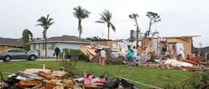 Eine Familie begutachtet die Schäden, nachdem Hurrikan „Milton“ ihr Haus in Martin County in Florida zerstört hat. 