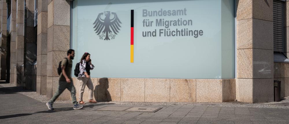 Menschen gehen an der Berliner Außenstelle des Bundesamtes für Migration und Flüchtlinge (BAMF) an der Ecke Bundesallee und Badensche Straße in Berlin-Wilmersdorf vorbei (Symbolbild).