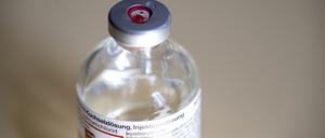 Ein Tropfen Kochsalzlösung ist neben dem Gummiseptum einer Injektionsflasche liegen geblieben. 