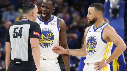 Ray Acosta (l.) und Stephen Curry von den Golden State Warriors diskutieren mit einem Schiedsrichter.