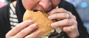 In einer McDonalds Filiale in Frankfurt beißt ein Mensch in einen Hamburger.