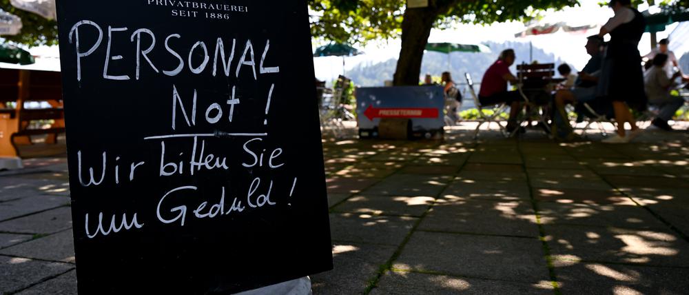 ARCHIV - 23.08.2024, Bayern, Oberaudorf: Ein Schild mit der Aufschrift "Personal Not! - Wir bitten Sie um Geduld!" steht am Eingang von einem Biergarten. (zu dpa: «Fachkräftelücke im Gastgewerbe fast um die Hälfte gesunken») Foto: Sven Hoppe/dpa +++ dpa-Bildfunk +++
