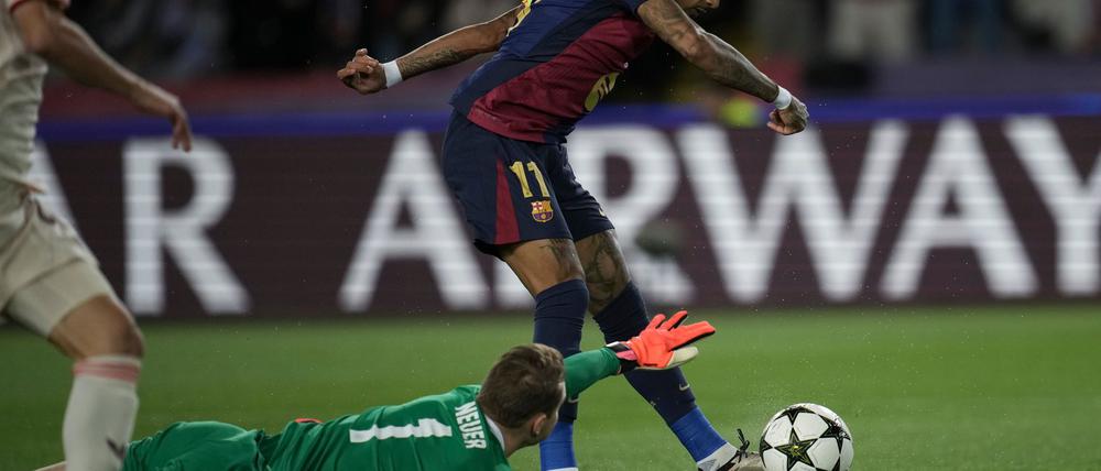 Manuel Neuer am Boden, hier beim ersten der drei Tore von Angreifer Raphinha (r) beim 1:4 in Barcelona.