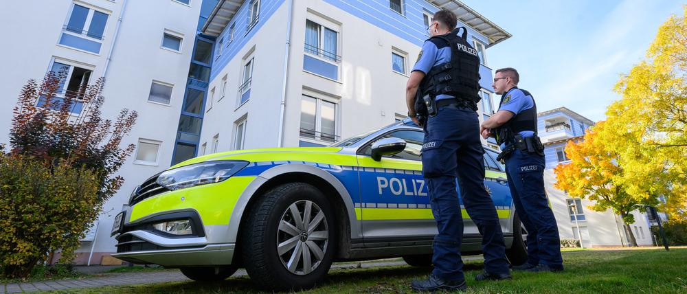 Polizisten stehen vor einem Mehrfamilienhaus in Leipzig, wo ein sieben Jahre altes Mädchen tödlich verletzt worden ist.