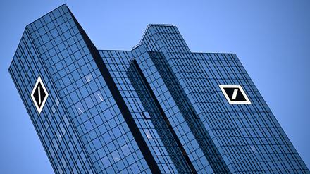 Das Logo der Deutschen Bank leuchtet am Morgen an der Fassade der Unternehmenszentrale in Frankfurt. 