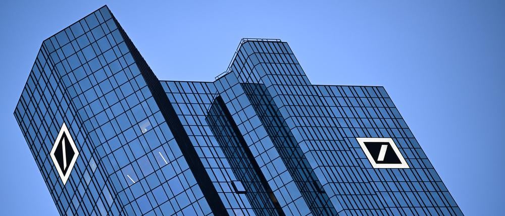Das Logo der Deutschen Bank leuchtet am Morgen an der Fassade der Unternehmenszentrale in Frankfurt. 