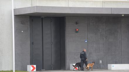 Ein Justizangehöriger geht mit zwei Hunden vor der Justizvollzugsanstalt Augsburg-Gablingen: Hier solle es mutmaßlich zu Gefangenenmisshandlung gekommen sein.