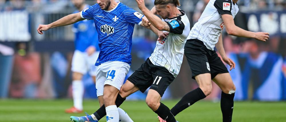 Darmstadts Killian Julian Corredor (l) und Ulms Dennis Chessa kämpfen um den Ball.