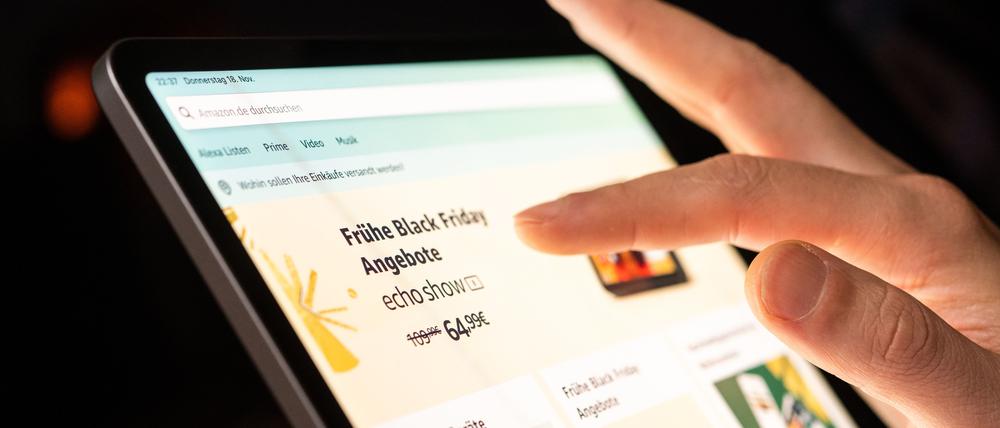 Eine Person schaut sich die Black-Friday-Angebote auf der Online-Shopping-Seite von Amazon auf seinem Tablet-Computer an.