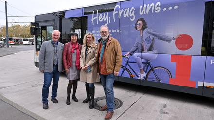 Rubelt, Sommer, Biffi und Jennert (v.l.) vor dem Bus mit Werbemotiv.