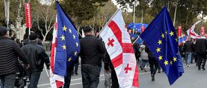 Menschen kommen mit georgischen und EU-Fahnen zu einer Demonstration in der georgischen Hauptstadt. 