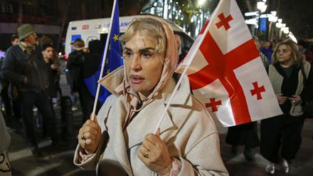 Eine Frau hält eine EU- und eine georgische Nationalflagge während eines Protestes der Opposition gegen die Ergebnisse der Parlamentswahlen.